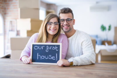 Couple holding sign "our first Home"